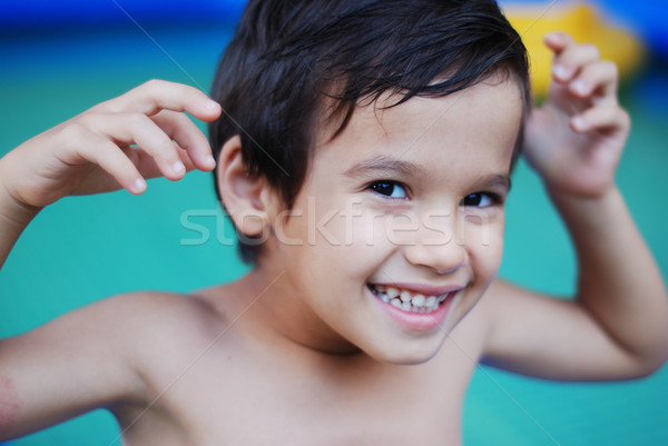 Stock photo: A cute kid in front of the green water