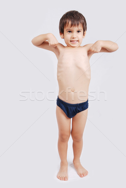 Portrait of little european boy flexing biceps. Beautiful caucasian model. Isolated on white backgro Stock photo © zurijeta