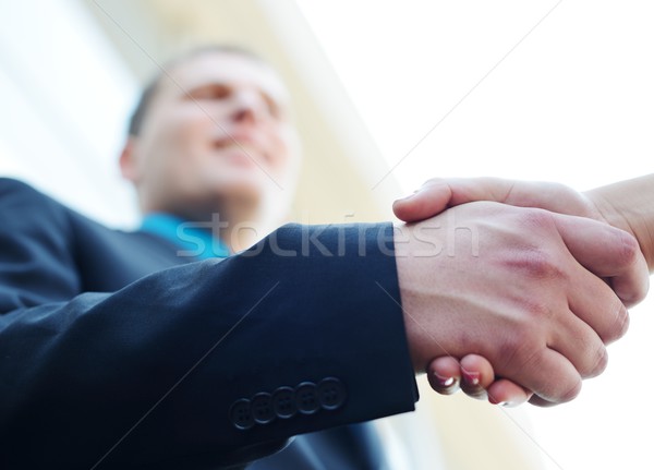 Business man and woman shaking hands. Bright modern building bac Stock photo © zurijeta