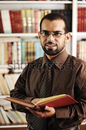 Stock photo: Young man reading book in library