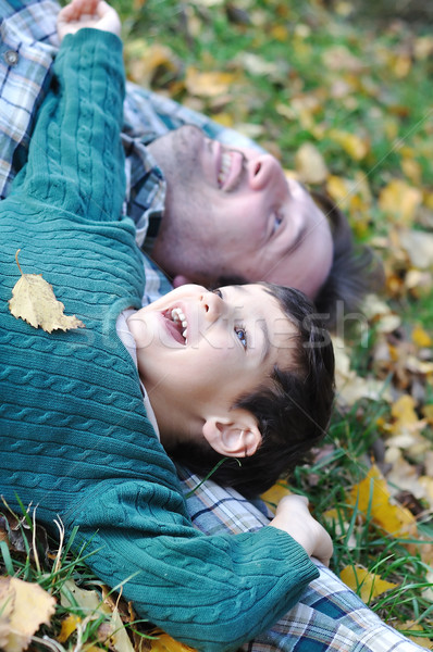 Happy positive young man with his kid on fall ground Stock photo © zurijeta