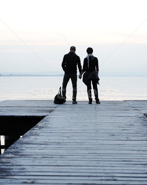 Stock photo: Couple by the wooden dock on a beautiful lake