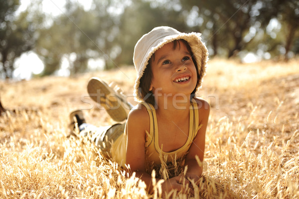 Careless boy on yellow grass meadow in autumn Stock photo © zurijeta