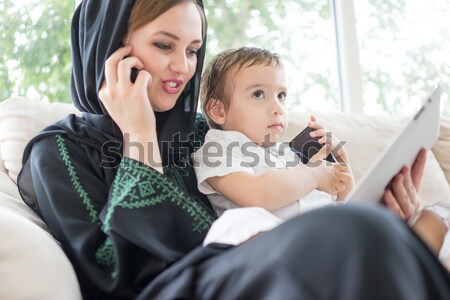 Stock photo: Happy Arabic family having fun time, mom and baby using gadget