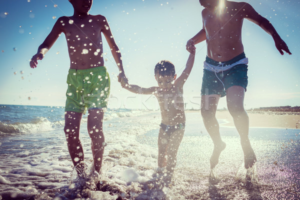 Fun kids playing splash at beach Stock photo © zurijeta