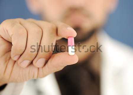 Doctor holding a pill, solution for you, closeup Stock photo © zurijeta