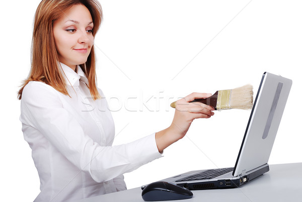 Female model is brushing/cleaning her laptop with brush Stock photo © zurijeta