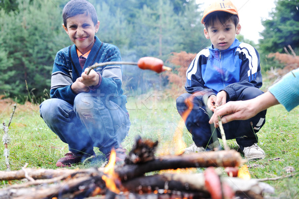 Barbecue in nature, group of people preparing sausages on fire (note: shallow dof) Stock photo © zurijeta