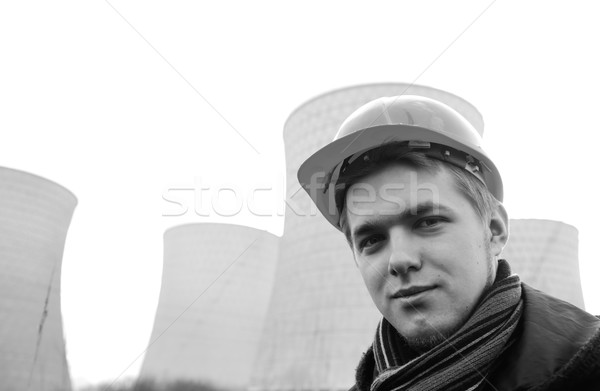 Stock photo: Engineer with protective helmet standing in front of nuclear pow