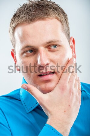 Handsome young man scratching his beard Stock photo © zurijeta