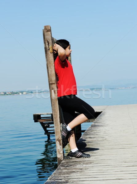 Stock photo: Girl on dock by the beautiful lake