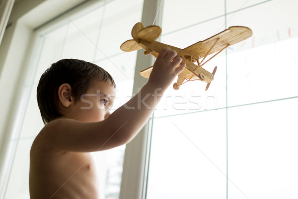 Happy little kid wants to fly with his airplane trough the windo Stock photo © zurijeta