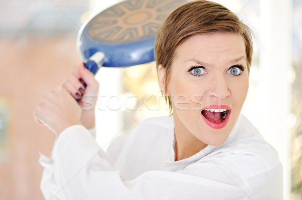 Mad woman with pan in hands Stock photo © zurijeta
