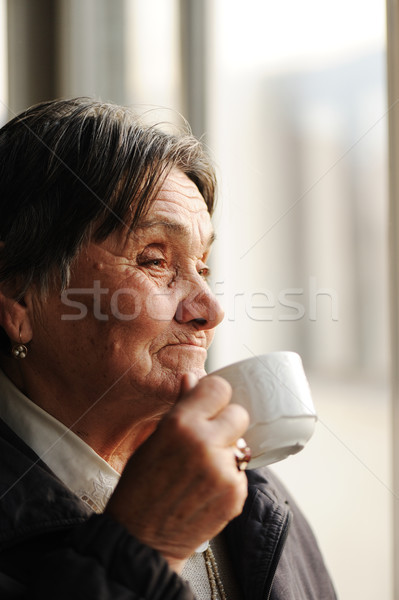 Portrait of Senior Woman Looking Through Window and Drinking Coffee Stock photo © zurijeta