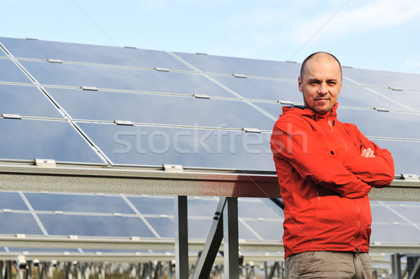 Young male engineer with solar panels in background Stock photo © zurijeta