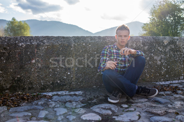 Young man on the old stone bridge with direct sunlight in backgr Stock photo © zurijeta
