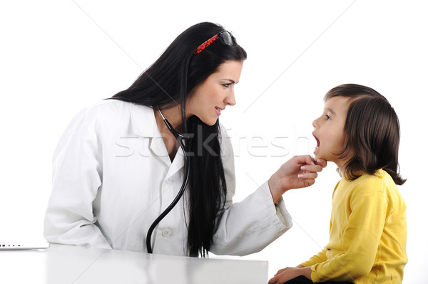 Female doctor examining child with tongue depressor Stock photo © zurijeta