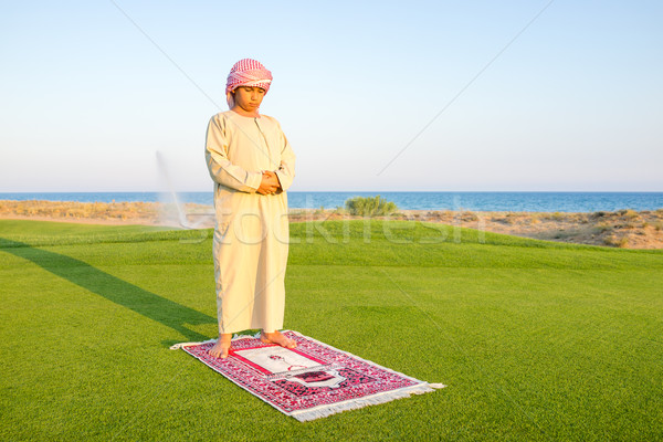 Muszlim arab fiú imádkozik zöld legelő Stock fotó © zurijeta