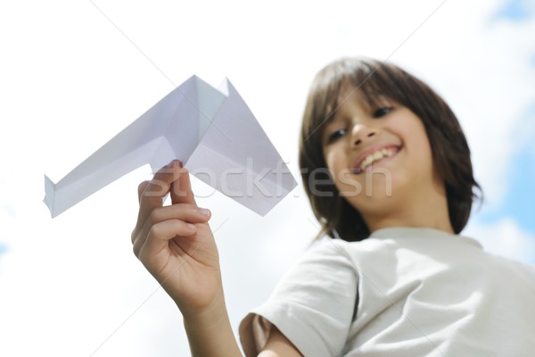 Kid flying a paper airplane Stock photo © zurijeta