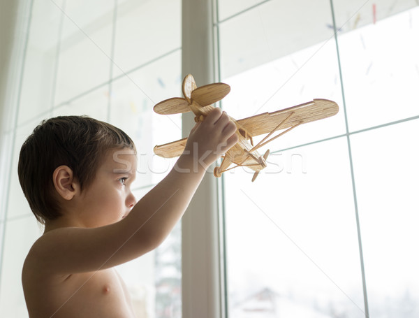 Happy little kid wants to fly with his airplane trough the windo Stock photo © zurijeta