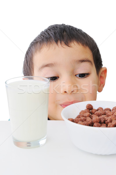 Stock photo: Kid looking at flakes and glass of milk