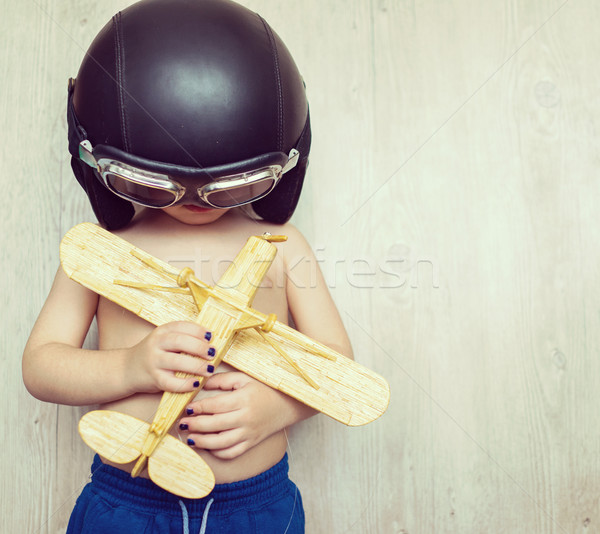 Happy little kid holding his toy plane on chest Stock photo © zurijeta