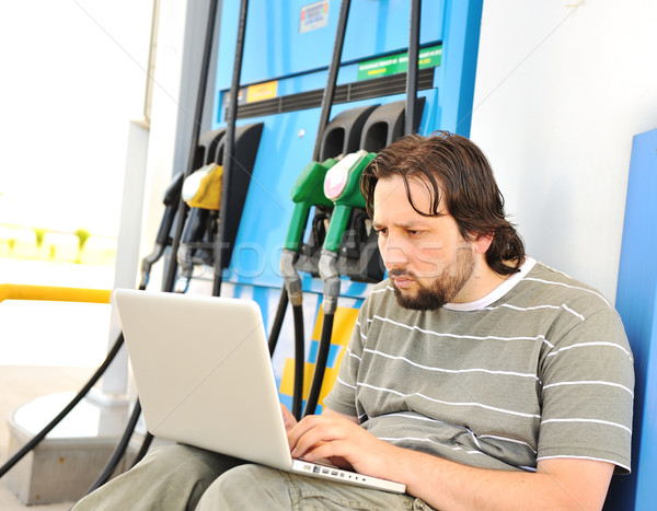 A man with worried face with laptop on fuel station Stock photo © zurijeta