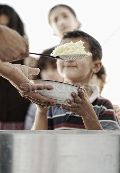 Stock photo: Hungry children in refugee camp, distribution of humanitarian food