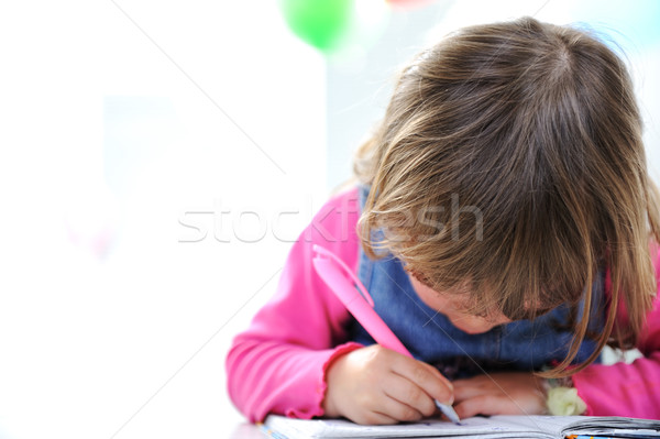 Little cute blond baby girl is drawing with pencil on paper, large copy space beside Stock photo © zurijeta