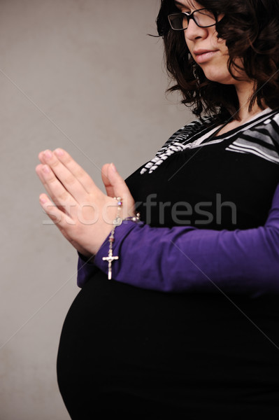 Pregnant woman praying with rosary in hands Stock photo © zurijeta