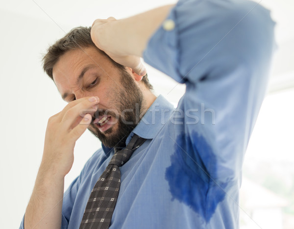 Business man with sweating under armpit in blue shirt Stock photo © zurijeta
