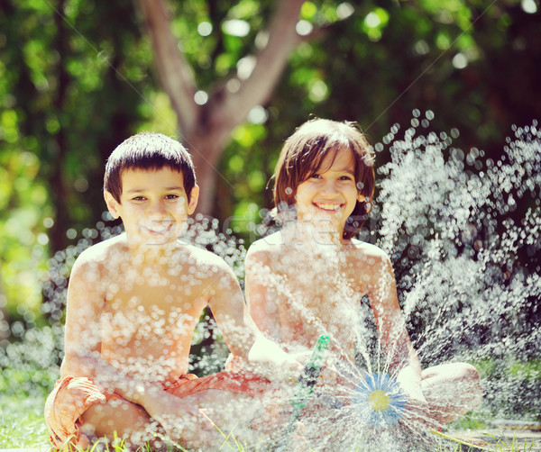 Gyerekek játszik csobbanás víz locsoló nyár Stock fotó © zurijeta
