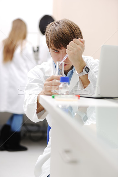 Young medical scientist working in modern lab, research with tubes and notebook Stock photo © zurijeta
