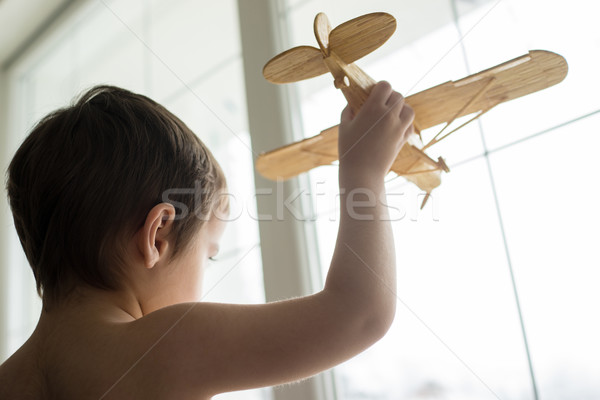 Happy little kid wants to fly with his airplane trough the windo Stock photo © zurijeta