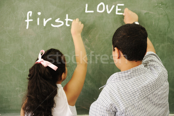 First love - boy and girl writing on board in classroom Stock photo © zurijeta