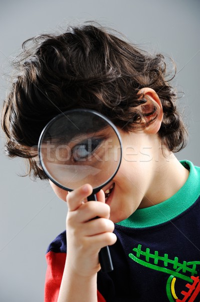 Portrait of child looking closely with magnifying glass Stock photo © zurijeta