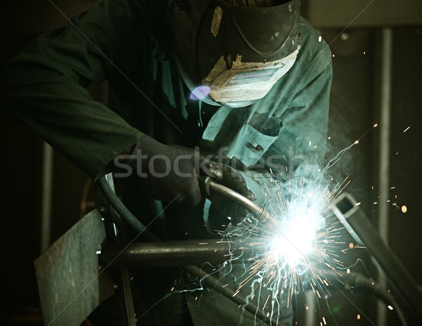 Stock photo: Welder with protective mask welding metal and sparks