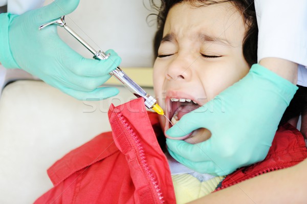 Kid visiting dentist office in hospital for pulling out milk too Stock photo © zurijeta