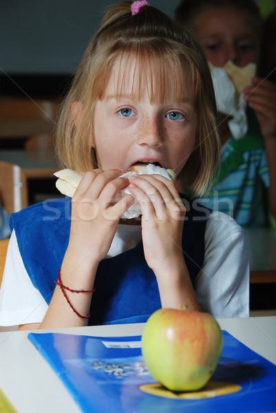 Little cute girl in classroom,  eating Stock photo © zurijeta