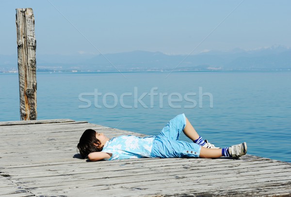 Stock photo: Boy on a beautiful lake dock
