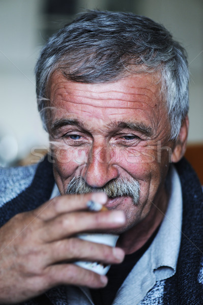Common elderly man with mustache smoking cigarette and drinking coffee Stock photo © zurijeta