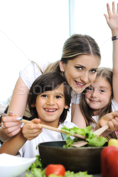 Beautiful mother with  little son and daugther in kitchen together Stock photo © zurijeta