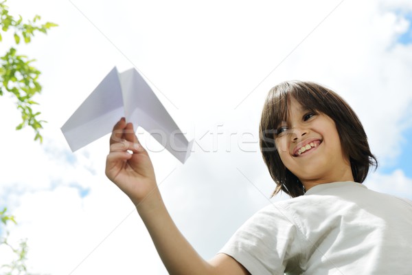 Kid flying a paper airplane Stock photo © zurijeta