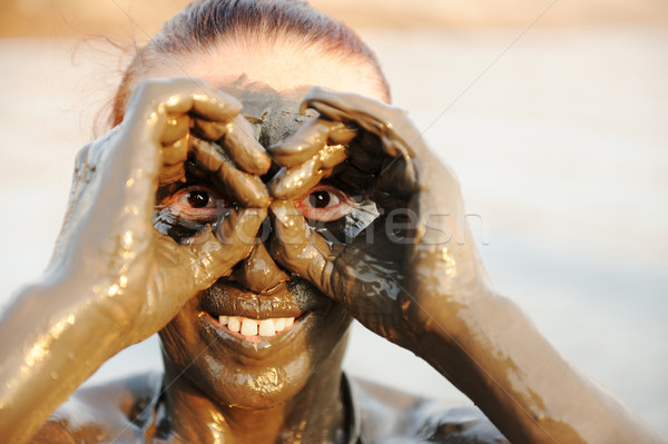 An elderly woman enjoying the natural mineral mud on face sourced from the dead sea in background Stock photo © zurijeta