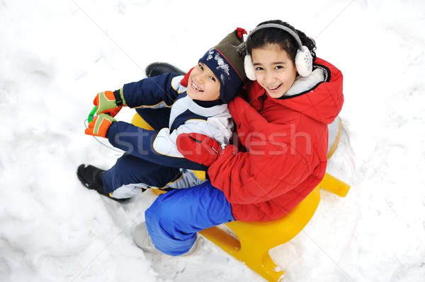 Kids sliding sledge in the snow Stock photo © zurijeta