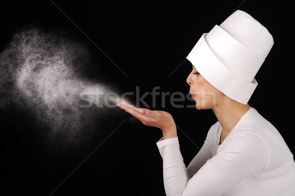 Beautiful woman blowing white powder on black background Stock photo © zurijeta