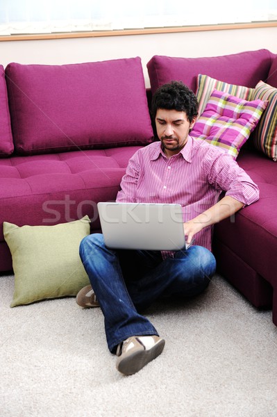 Jonge man sofa laptop computer huis glimlach Stockfoto © zurijeta