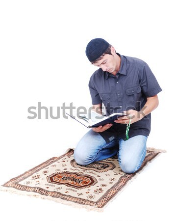 Muslim man is holding holly book Qoran and praying on traditiona Stock photo © zurijeta
