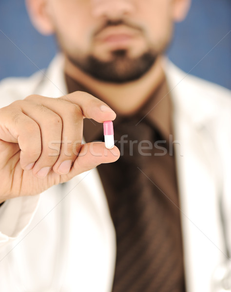 Doctor holding a pill, solution for you, closeup Stock photo © zurijeta