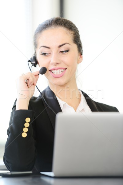 Female call centre employee speaking over the headset Stock photo © zurijeta